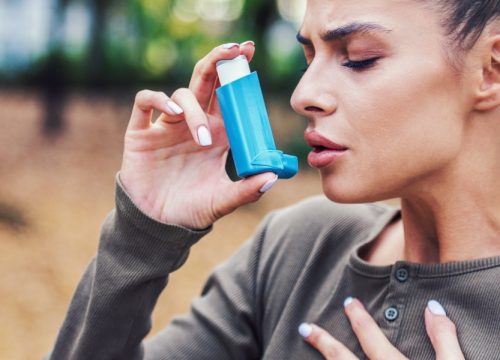 Woman using her inhaler