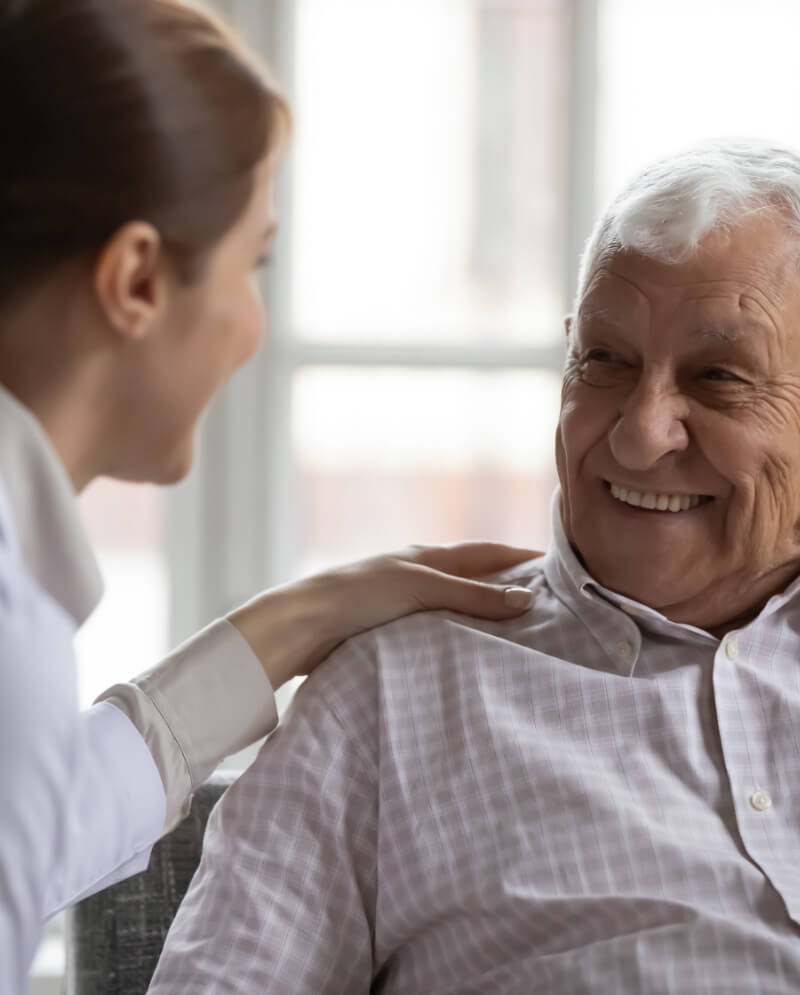 Older man smiling at a doctor