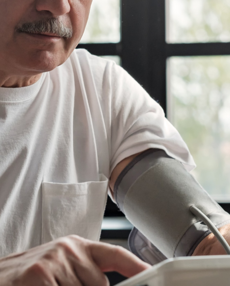 Older man with a mustache checking his blood pressure