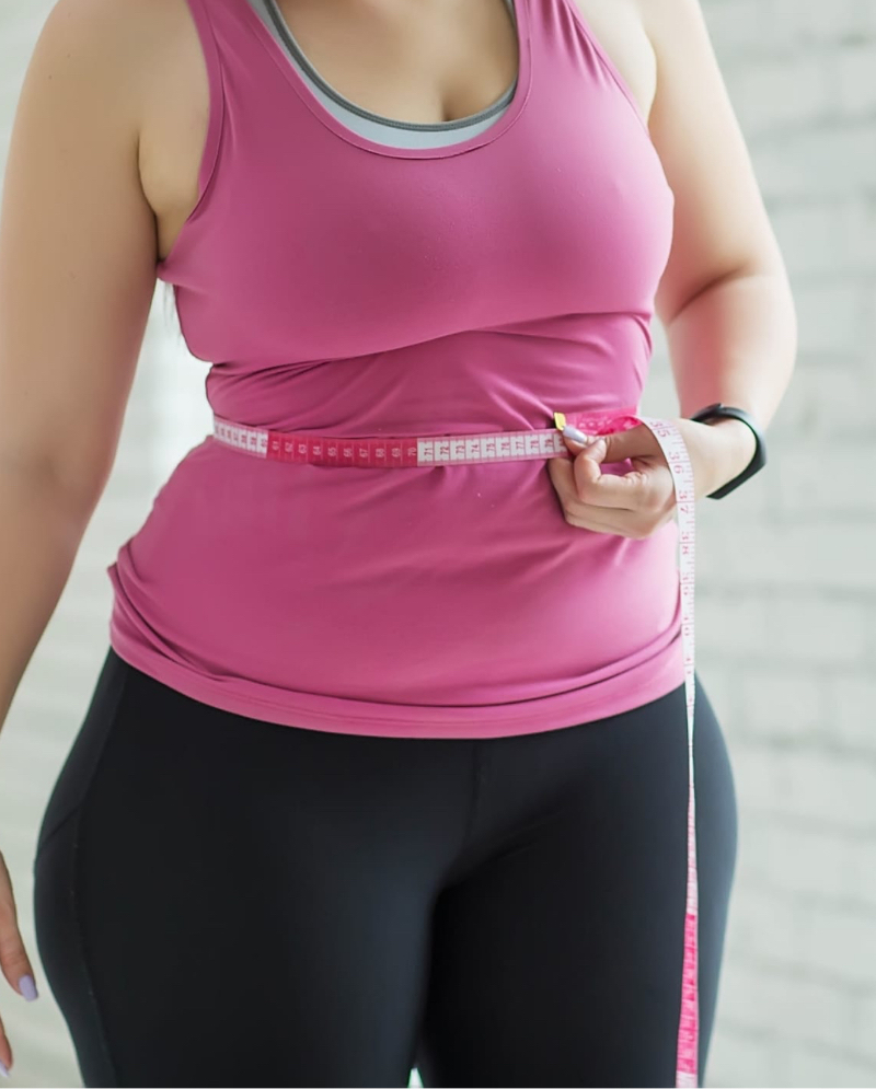 Woman measuring her waist