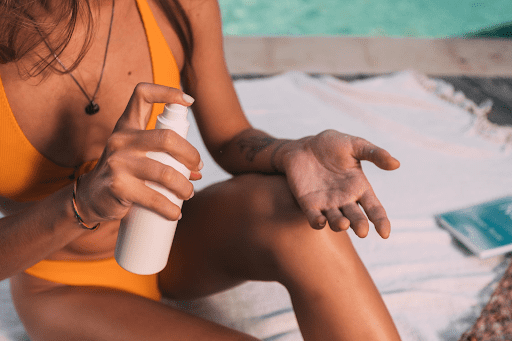 Woman applying sunscreen, poolside
