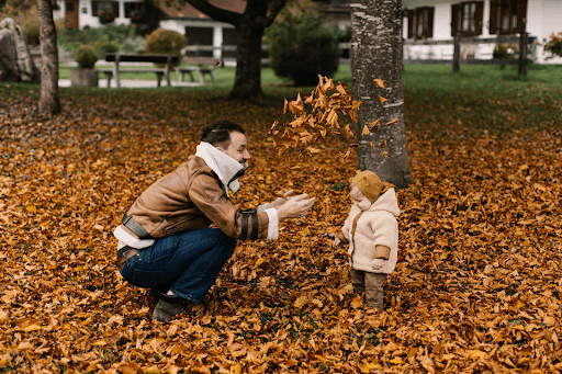 Father playing in the leaves with his daughter