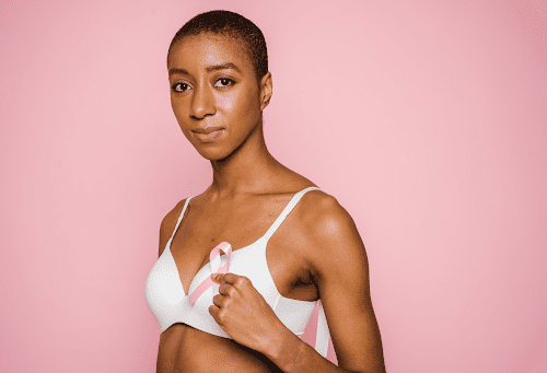 Breast cancer survivor holding up a pink ribbon